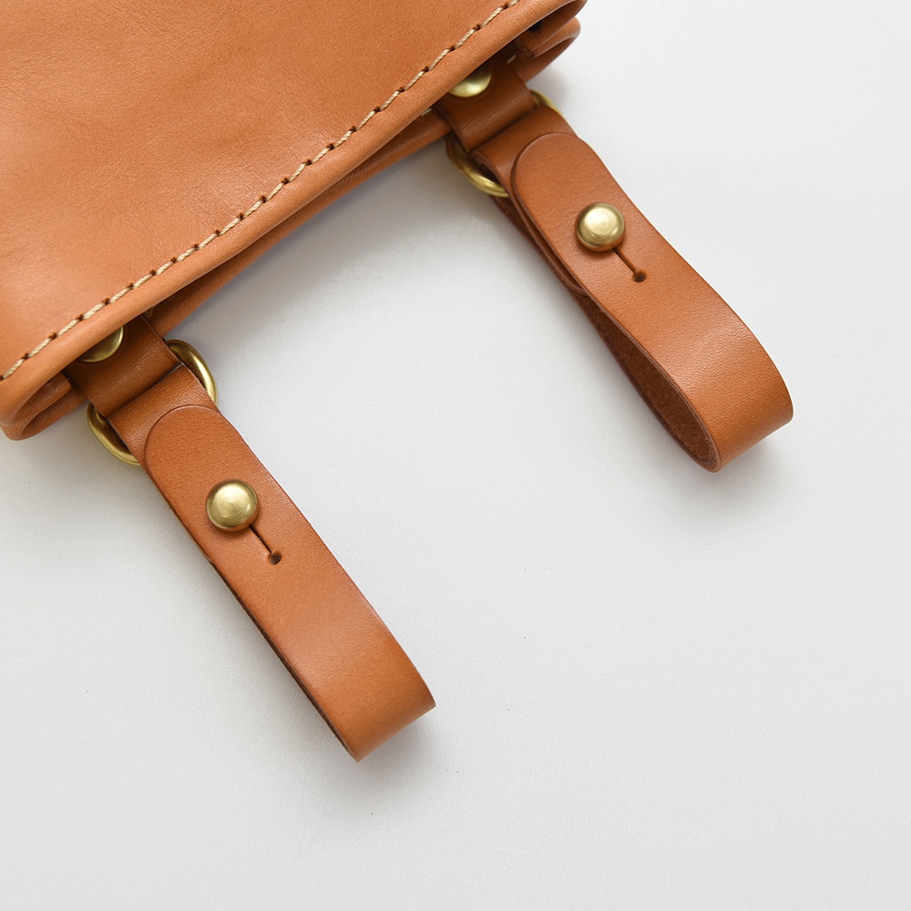 職人手作皮革多用途工作用腰袋 E-27，特寫鏡頭展現淺棕色皮革材質，縫線清晰，附有黃銅色五金釦環及鉚釘。