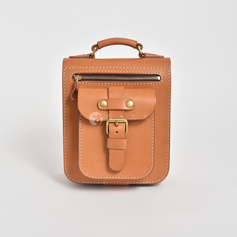 職人手作咖啡色皮革立體口袋兩用單肩包，配有黃銅釦環、拉鍊及頂部提把。
