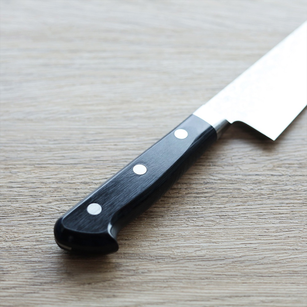 VG10不鏽鋼鎚目牛刀，黑色手柄，銀色鉚釘，刀刃部分為銀色不鏽鋼材質，刀柄呈現木紋質感。