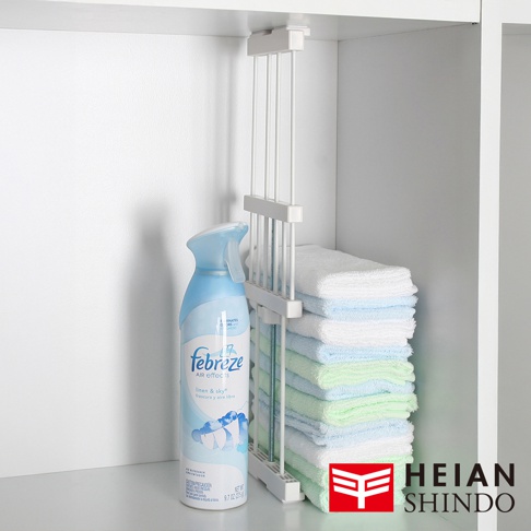 平安伸銅全功能伸縮縫隙置物架，搭配 Febreze 空氣清新噴霧，架上整齊疊放多條毛巾。