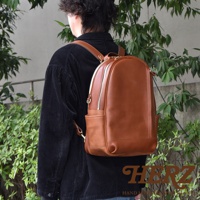 職人手作皮革多功能後背包 R-21，採用鞣製皮革製成，主體為棕色，配有雙拉鍊主隔層、前方拉鍊口袋及兩側開放式側袋，簡約實用。