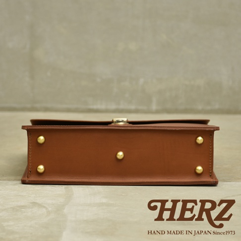 職人手作皮革Organ兩用商務公事包 G-93，棕色，側面展示。光滑皮革表面，配有金色金屬鈕扣和搭扣。