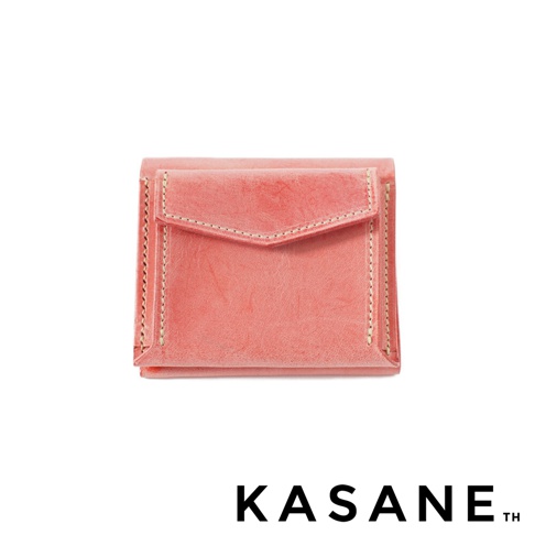 KASANE TH 品牌標誌旁是個別緻的粉紅色皮革短夾，有著縫線裝飾的翻蓋設計。