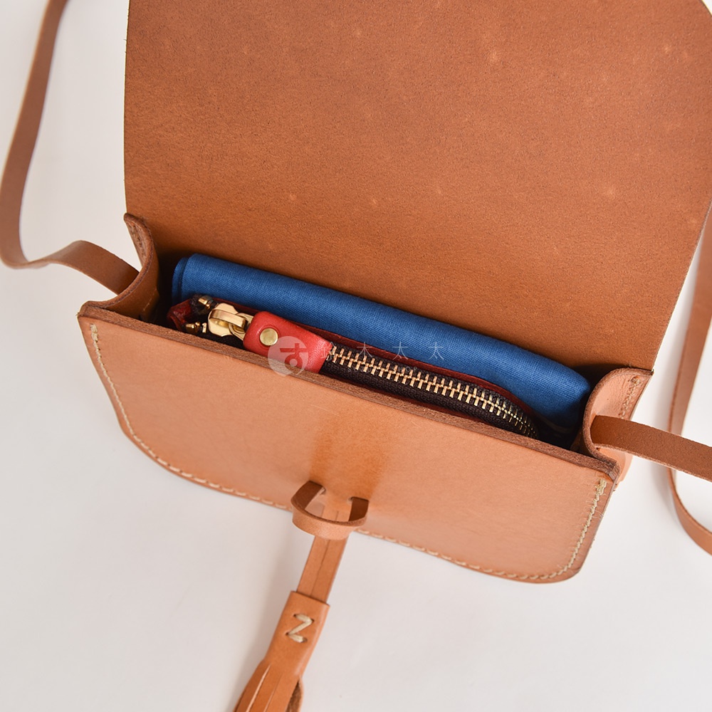 職人手作皮革流蘇側背包 CP-18，淺棕色皮革，包內有藍色布料和拉鍊零錢包，零錢包上有紅色皮革拉環。
