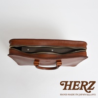 棕色皮革手提商務公事包，拉鍊部分開啟，露出內部文件夾。 雙提把設計，金屬拉鍊。