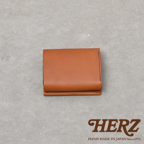 日本HERZ職人手作Organ系列皮革迷你短夾，選用義大利Minerva Liscio皮革製作，外觀呈現簡約俐落的焦糖棕色長方形設計，右側帶有精緻的手工縫線細節，整體展現高品質皮革的天然質感。
