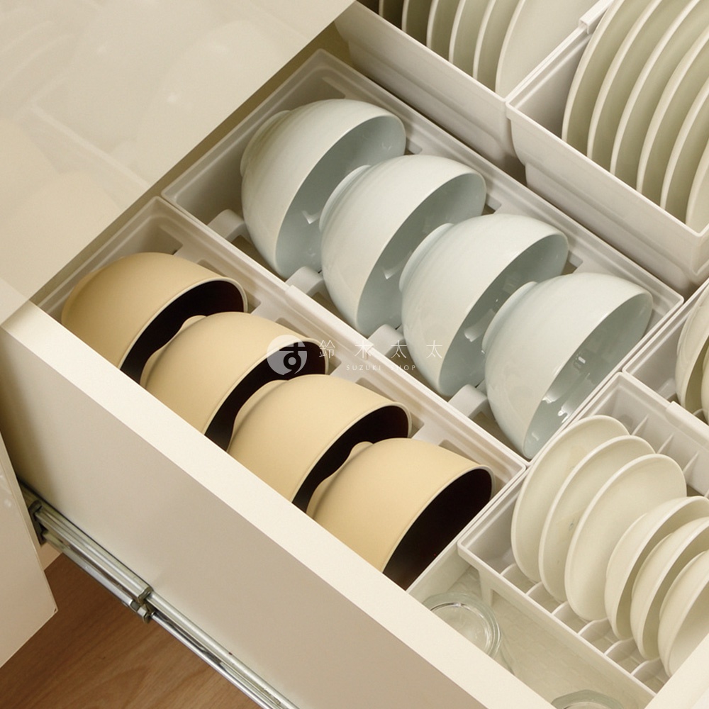 抽屜式餐碗收納架整齊擺放著多個淺米色和白色的碗，部分碗內還有白色盤子。