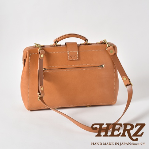 職人手作皮革軟式杜勒斯三用背包，呈現自然棕色，以高品質皮革製成，配有頂部提把、側邊可拆卸背帶及前方拉鍊口袋，設計簡約實用。