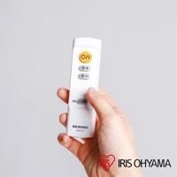 手持白色遙控器，上面有黃色電源按鈕及亮度調整按鈕。遙控器下方印有「IRIS OHYAMA R5.0-D」字樣。