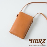 職人手作皮革手機包 CP-11，採用淺棕色皮革製成，設計簡約，附有同色系皮革細長背帶，適合日常攜帶手機。