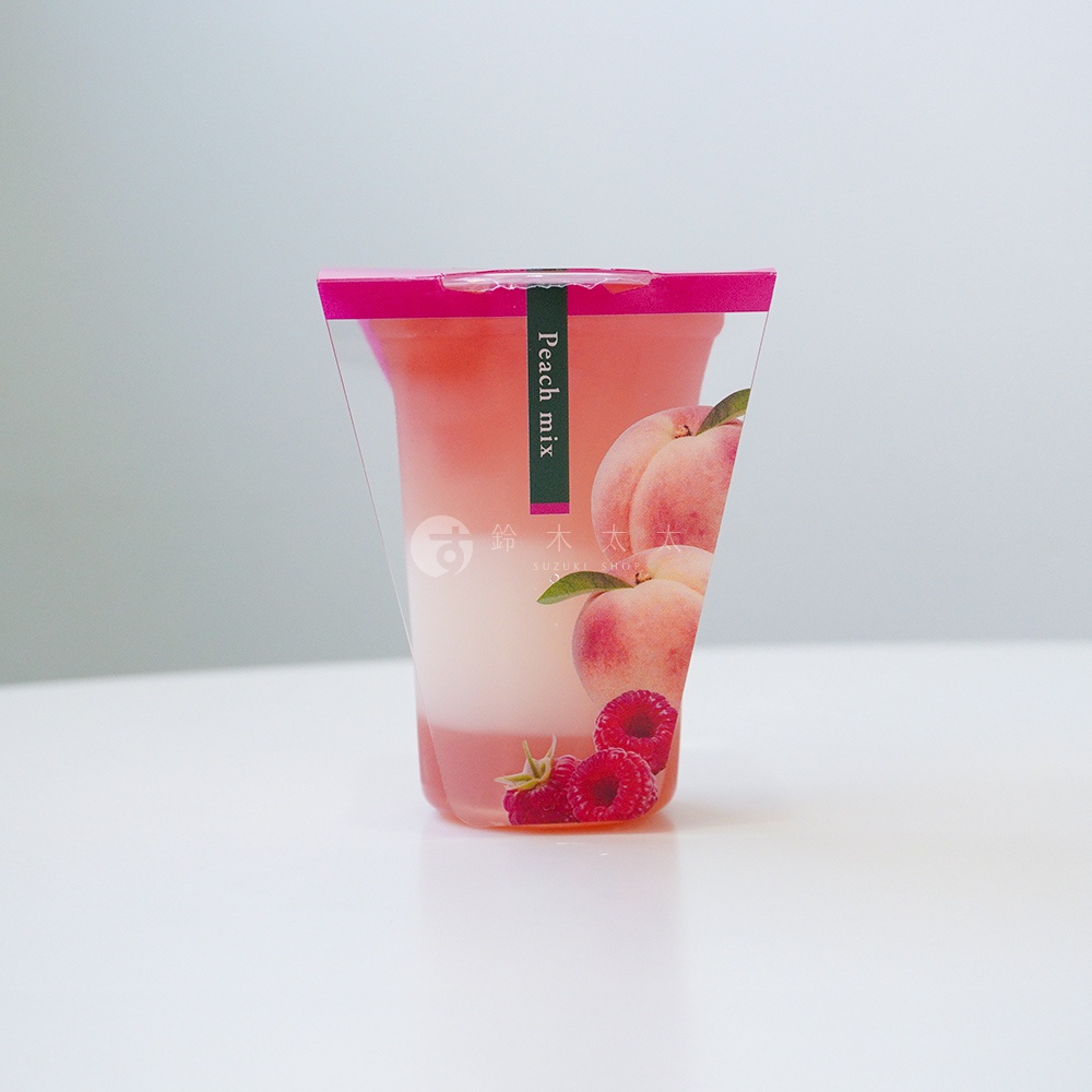 透明杯裝著粉紅色果凍飲料，杯身印有水蜜桃與覆盆子圖案，並有「Peach mix」字樣的綠色標籤。