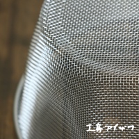 不鏽鋼網篩近拍，顯示細密的金屬網格紋理，網篩邊緣有部分反光。