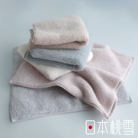 日本桃雪今治棉蕾超無撚蓬鬆毛巾，堆疊展示，包含粉色、灰色、白色和淺藍色等多種柔和色調，觸感蓬鬆柔軟。