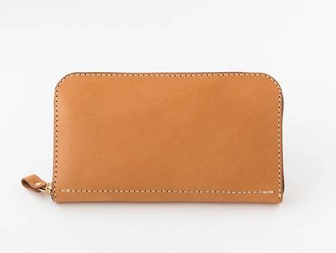 職人手作皮革大容量拉鍊長夾，採用天然棕色皮革製成，觸感溫潤，車縫線整齊細緻，配有金色金屬拉鍊及同色系皮革拉頭，設計簡約實用，展現皮革的自然紋理與質感。