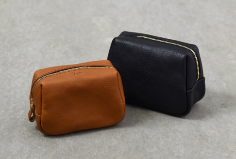 職人手作皮革Organ拉鍊收納包 (GS-63) S，一個為棕褐色，另一個為黑色，皆為方形立體設計，採用帶有紋理的皮革材質，搭配金色拉鍊。