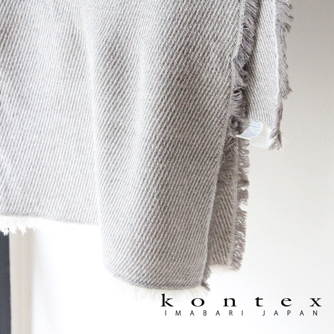 SWELL 質感流蘇鬆餅紋長毛巾，近拍展示淺灰色與深灰色交織的斜紋織法，毛巾邊緣有細緻的流蘇裝飾，質感柔軟。