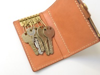 職人手作皮革拉鍊零錢鑰匙包，採用天然棕色皮革製成，內有四個金屬鑰匙鉤，可掛置鑰匙，並附有拉鍊開合。