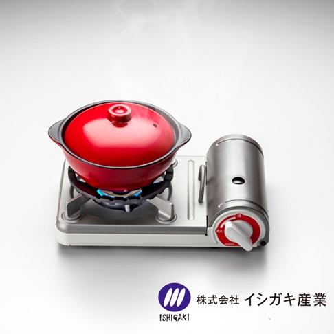 紅色陶鍋置於金屬瓦斯爐架上，瓦斯爐架為銀白色，側邊配有銀灰色燃料罐，爐架下方有藍色火焰。