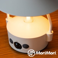 米白色圓柱形智慧感應燈，頂部有燈泡，側面有黑色感應器及ON/OFF、AUTO等按鈕，燈光溫暖。