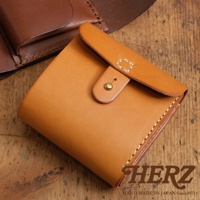 職人手作皮革原子釦型二折式短夾，呈現自然 tan 色調，皮革材質，帶有精緻縫線與金屬原子釦。