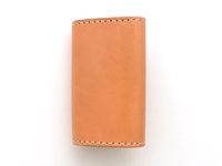 淺棕色皮革製作的經典鑰匙包，採用手工縫線，六鉤設計，簡潔實用。