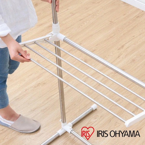 可伸縮不鏽鋼曬衣架，具有白色塑膠支架和多層銀色金屬晾曬桿，方便掛取衣物。