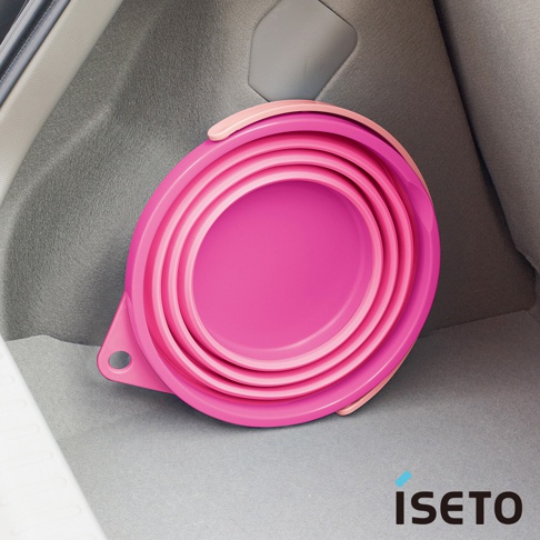 可折疊的圓形旅行水桶，採用粉紅色矽膠材質製成，具有多層同心圓設計，方便收納。