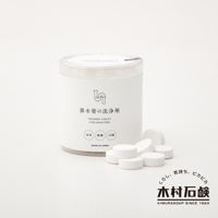 白色圓形塑膠罐裝著排水管清潔錠，罐身印有黑色圖案和「排水管の洗浄剤」日文及「WASHING TABLET FOR DRAIN PIPE」英文。罐旁散落幾顆白色圓柱形清潔錠。右下方有日文及英文品牌標誌。