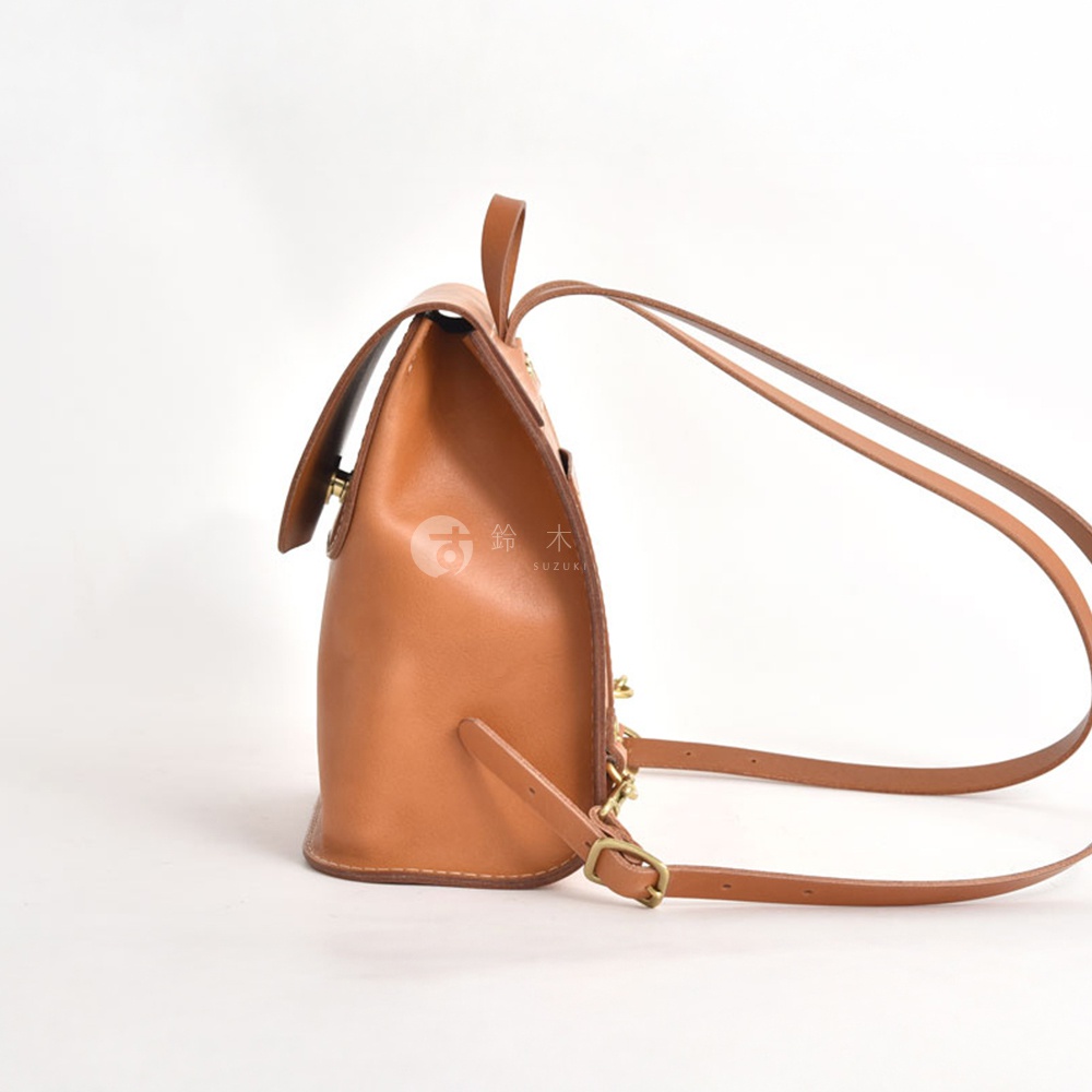 職人手作皮革翻蓋迷你後背包，採用棕褐色光滑皮革製成，配有可調節的皮革肩帶和銅色金屬扣環。