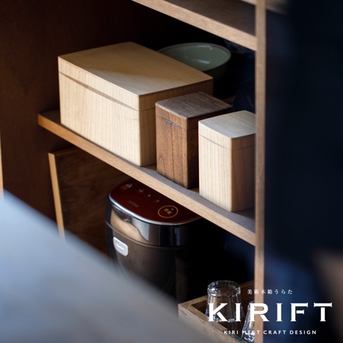淺色桐木製儲物盒，帶有木紋，與深色木製儲物盒並排放在木架上，下方有一個紅色電飯煲。