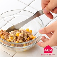 銀色金屬材質的抹刀，正在混合碗中的鮪魚玉米沙拉。