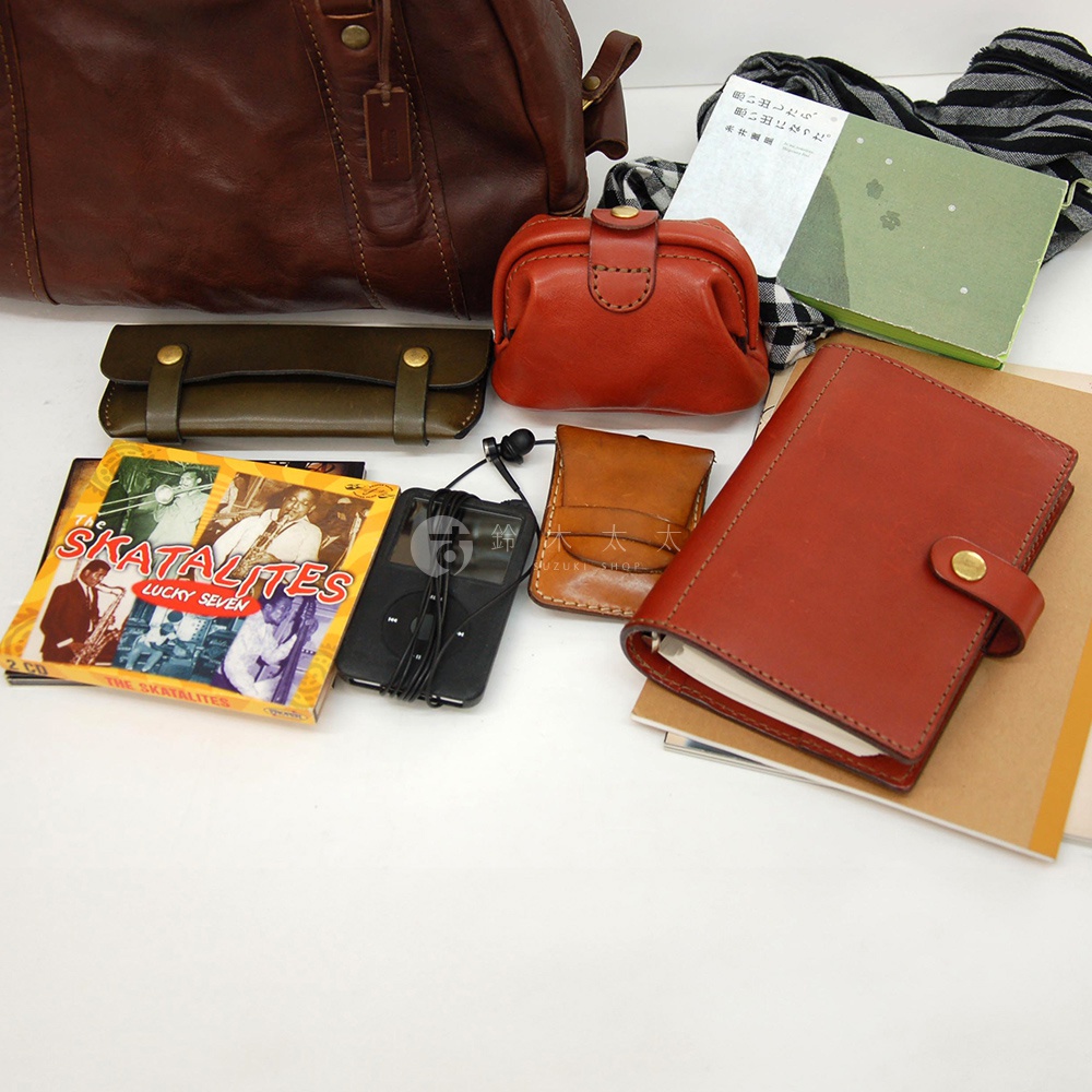 皮革迷你波士頓包，手感柔軟，搭配零錢包、卡夾、CD和播放器，展現復古生活風格。