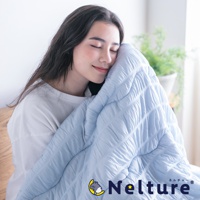 淡藍色單人被，表面有菱格紋縫線，質地輕柔，由一位女子抱著。