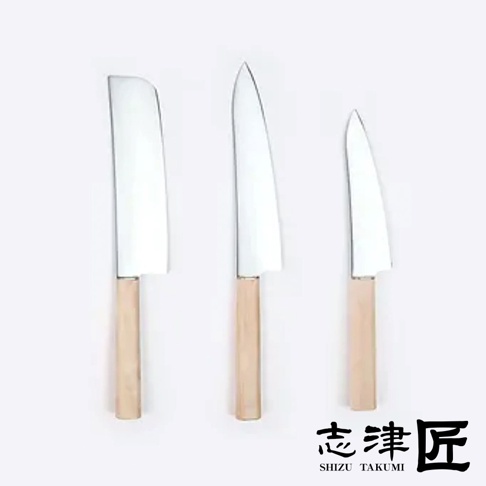 三把不銹鋼刀具，刀刃閃亮，配有淺木色手柄。從左至右分別為一把刀頭呈方形的萬用刀、一把刀尖銳利的Santoku刀，以及一把較小的Santoku刀。