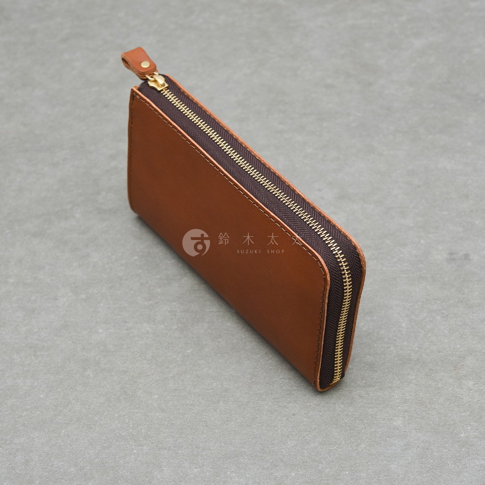 一個棕色皮革拉鍊長夾，上面印有鈴木太 SUZUKI SHOP 的標誌