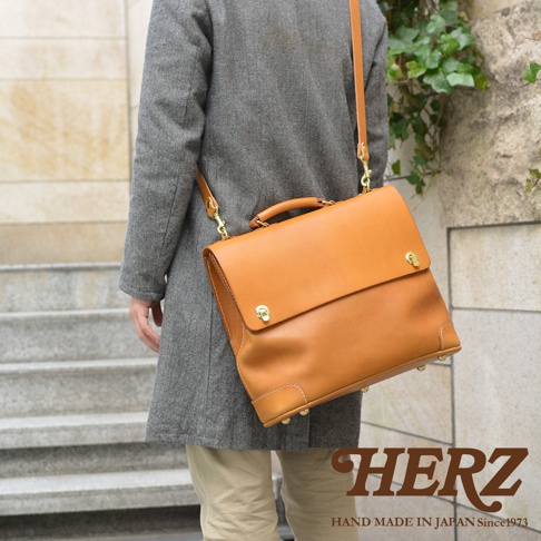 職人手作皮革旅行商務兩用波士頓包，採用天然棕色皮革，配有金屬鎖扣和加固底部。此款包包可肩背或手提，設計簡約實用。