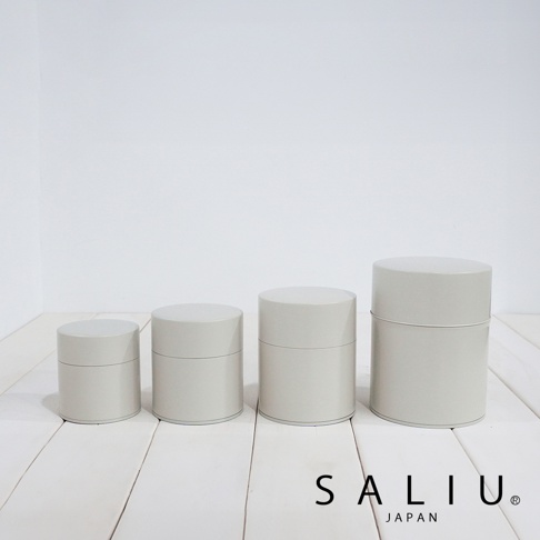 四個不同尺寸的淺灰色圓柱形錫製茶葉罐，帶有銀色蓋子和邊緣裝飾，呈排列狀。