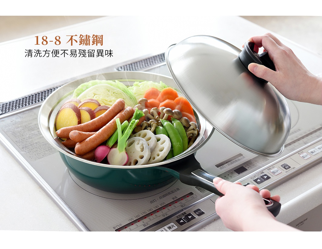不鏽鋼蒸盤內盛放著香腸、地瓜、蓮藕、豌豆、蘑菇、紅蘿蔔及高麗菜等食材，盤緣為銀色不鏽鋼，盤身為深綠色。一隻手正將銀色不鏽鋼鍋蓋蓋上。