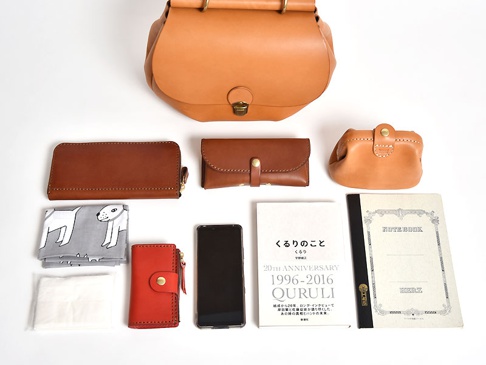 収納例。A5ノート、単行本、スマートフォン、ハンカチ、ポケットティッシュ、ファスナー長財布(WL-58)、小銭入れ付きキーケース(KE-130-N)、ベルト留めのメガネケース(KG-123-M)、ガマ口ポーチ(KF-143-M)。