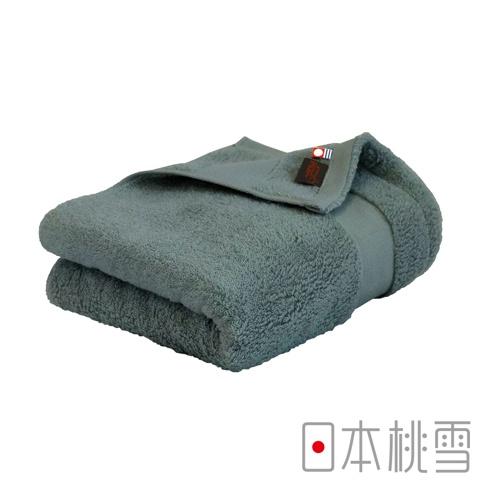 一條折疊的灰綠色今治匹馬棉浴巾，帶有品牌標籤。