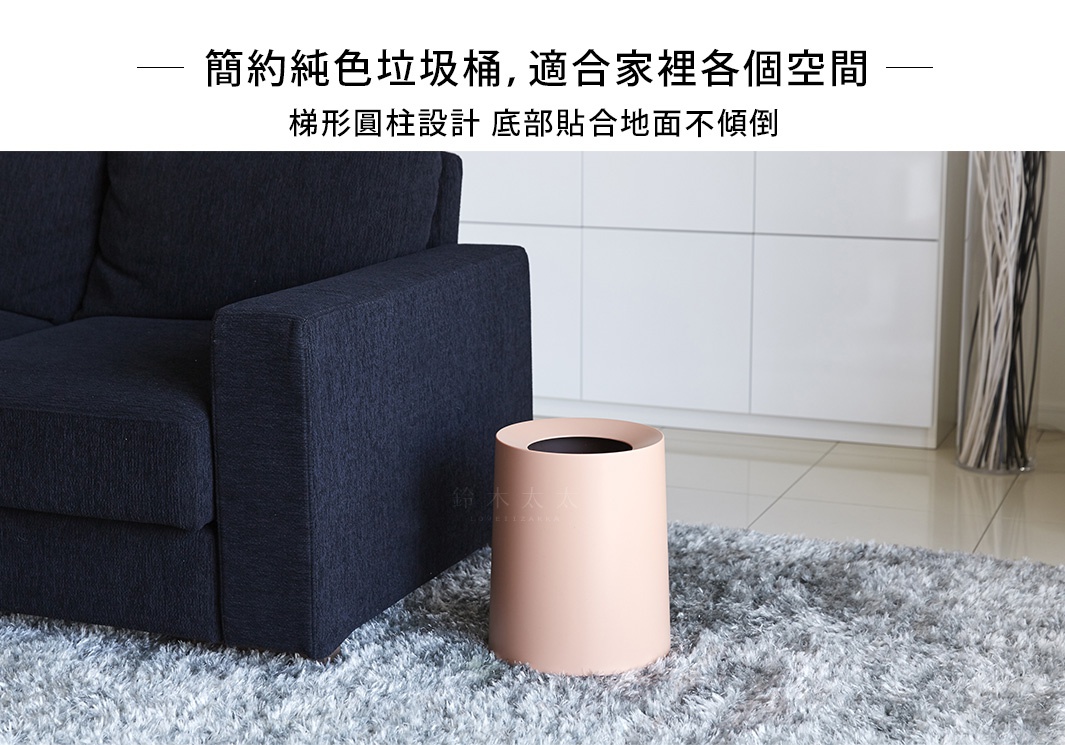 淺粉色圓形家用垃圾桶，梯形圓柱設計，底部貼合地面，材質為塑膠。