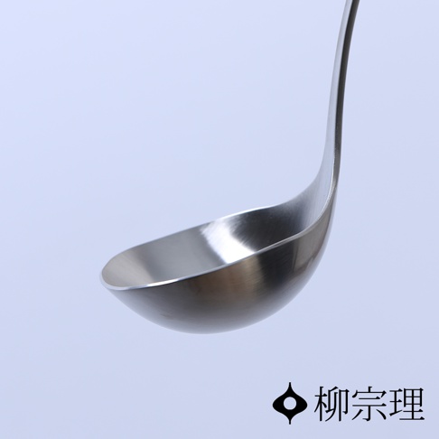 這是一張柳宗理不鏽鋼湯勺的特寫鏡頭，湯勺呈現霧面金屬質感，優雅的弧形設計展現出日式極簡美學，右下角配有柳宗理的品牌標誌與中文字樣。