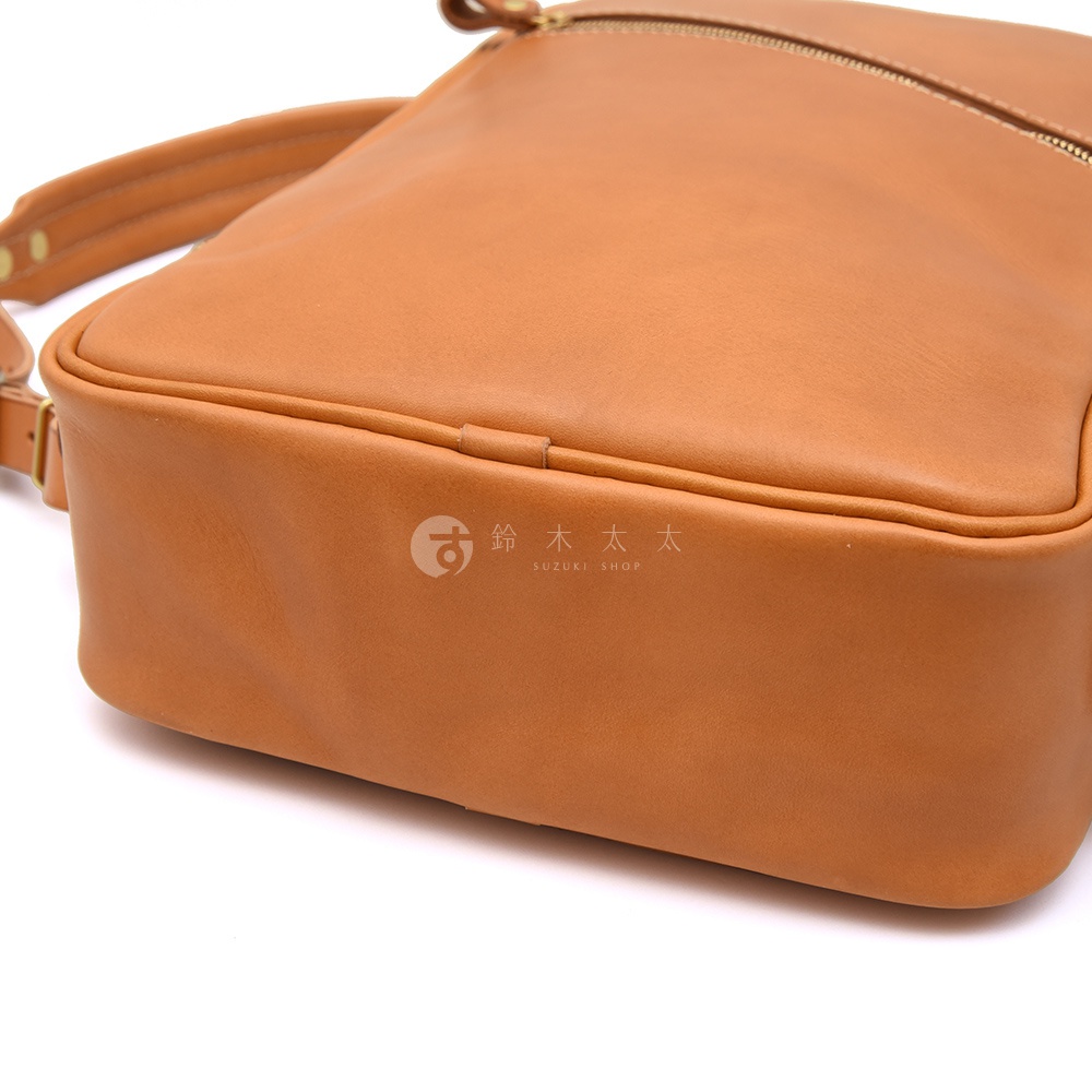 棕色皮革後背包，展示包包底部與側邊的皮革質感，可見縫線細節與品牌標誌。