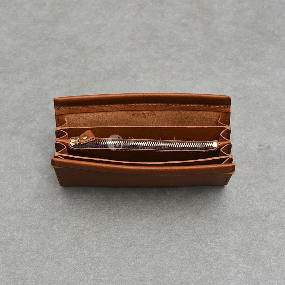 這款日本HERZ職人手作皮革長夾呈現咖啡色調，採取上方開口視角。長夾內部結構豐富，設有中央拉鍊式零錢袋與多層皮革夾層，整體以植鞣革製成，展現溫潤細膩的皮革紋理與手工縫製細節，整體設計簡約實用。