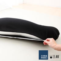 一個黑色的長條形抱枕，其拉鍊部分被一隻手拉開，露出內部白色的襯裡，整體呈現簡潔的設計。