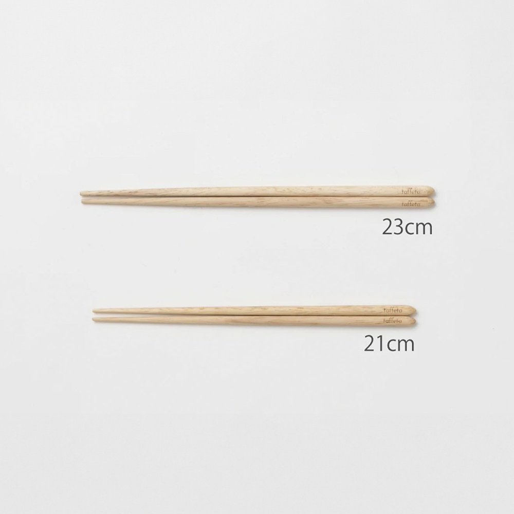 一雙淺色楓木圓筷，一雙長度為 23 公分，另一雙為 21 公分，筷子末端有品牌標誌。