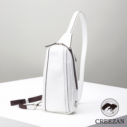 JETTER 隨身側背包 CJTE-021，白色荔枝紋皮革材質，單肩背帶，主拉鍊開口，前方有小口袋，配有深棕色織帶和銀色金屬扣環。