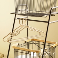 Mash移動式雙層分類洗衣置物籃，黑色金屬支架，上方有一個黑色線條編織的洗衣籃，下方掛有數個淺米色塑膠衣架，最底層有一個黑色金屬線條編織的洗衣籃，籃緣帶有木質邊框。
