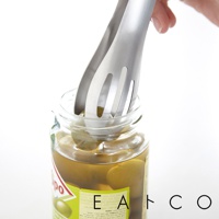 銀色不鏽鋼單邊孔料理夾，正在從裝有橄欖的玻璃罐中夾取橄欖。