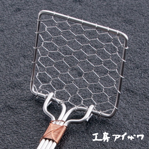 不鏽鋼製方的濾網勺，網目為菱形，柄部焊接處以銅線纏繞固定。